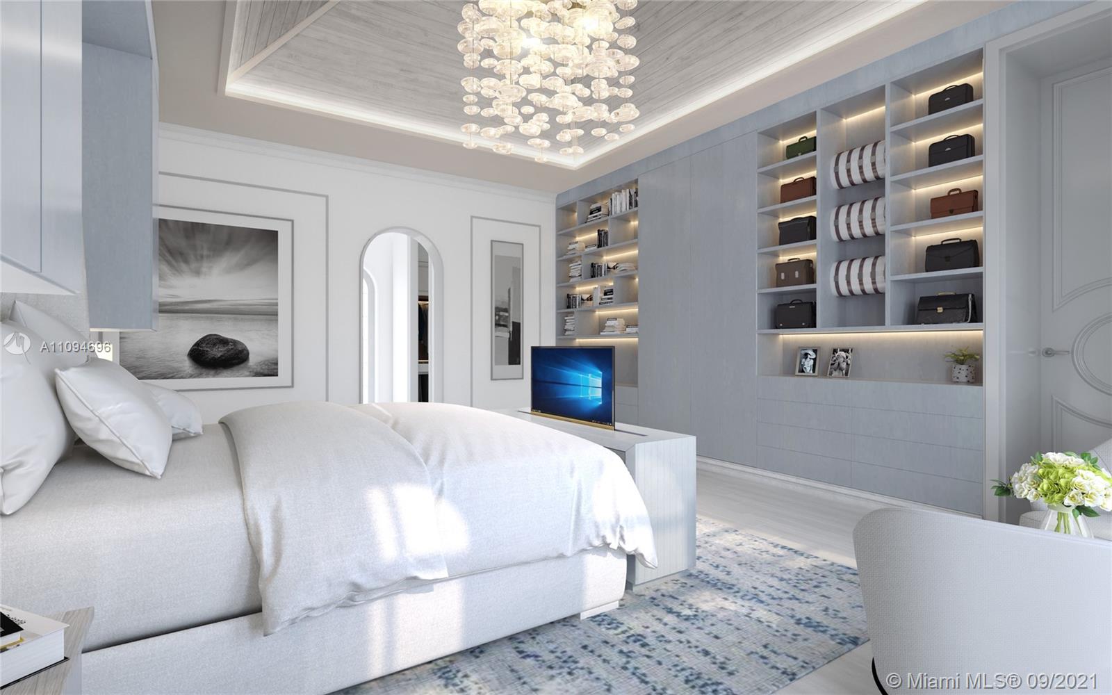 5465 Pine Tree Drive Miami Beach, FL 33140 - Photo 10 of 18 a bedroom with a large bed and a chandelier