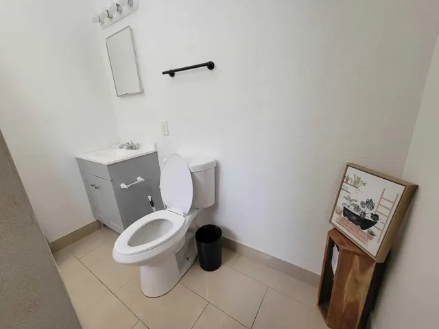 a white toilet sitting next to a bathroom sink and vanity