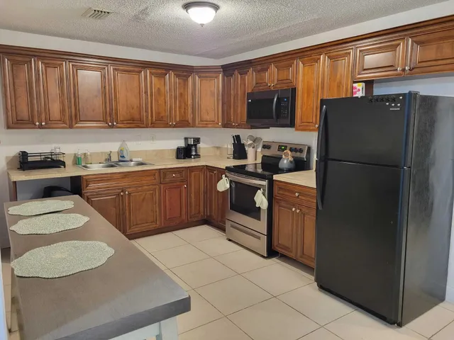 a kitchen with a sink a stove a refrigerator and a microwave