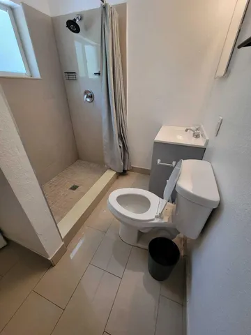 a bathroom with a sink toilet and shower