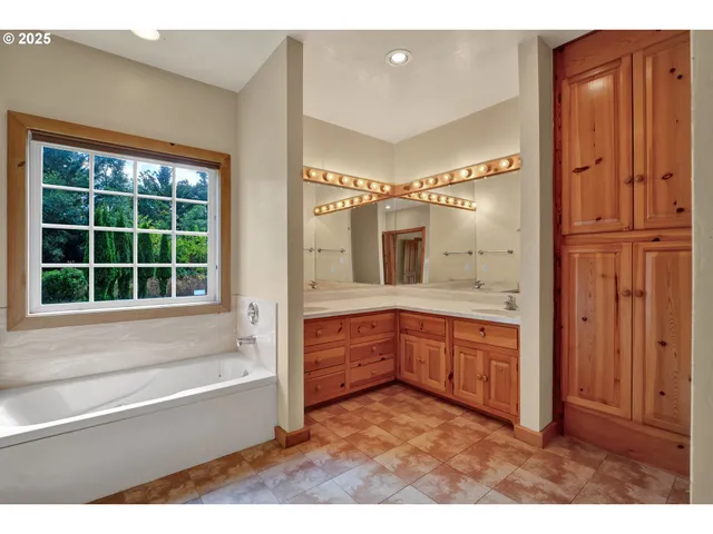 a bathroom with a tub sink and mirror