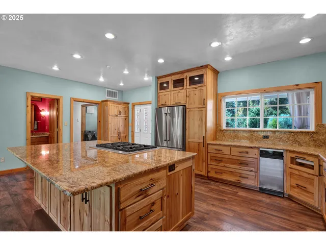 a kitchen with stainless steel appliances granite countertop a kitchen island a stove and a sink