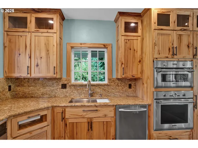 a kitchen with stainless steel appliances granite countertop a stove a sink and a granite counter tops
