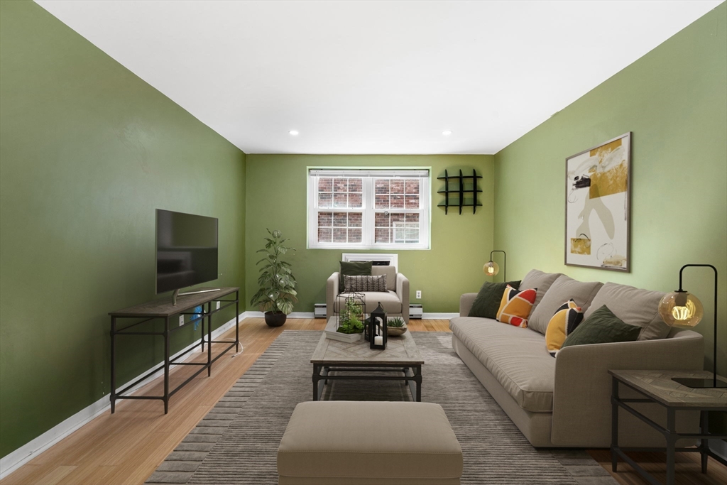 a living room with furniture wooden floor and a flat screen tv