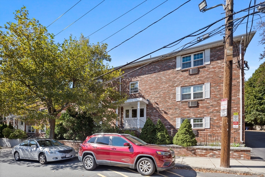 116 Sycamore Street, Unit 22 Somerville, MA 02145 - Photo 17 of 18 a front view of a house with parking area