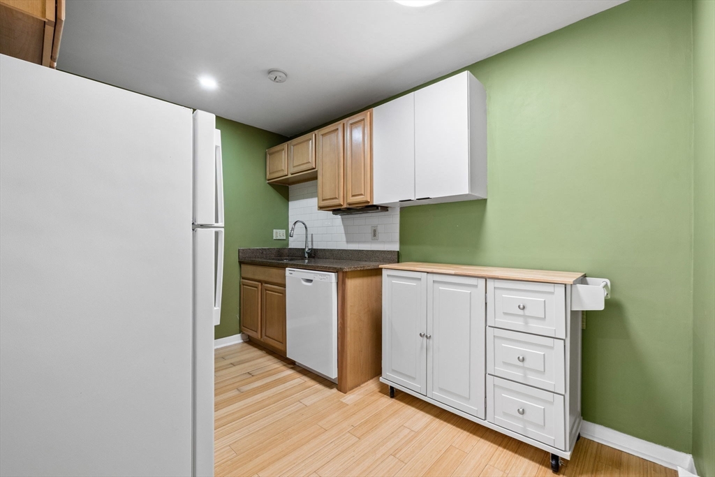 116 Sycamore Street, Unit 22 Somerville, MA 02145 - Photo 4 of 18 a kitchen with cabinets appliances and a wooden floor