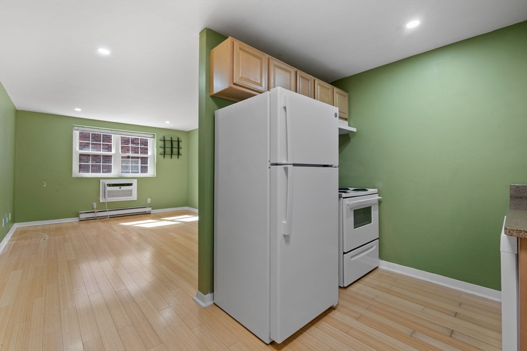 116 Sycamore Street, Unit 22 Somerville, MA 02145 - Photo 5 of 18 a view of kitchen with refrigerator and wooden floor