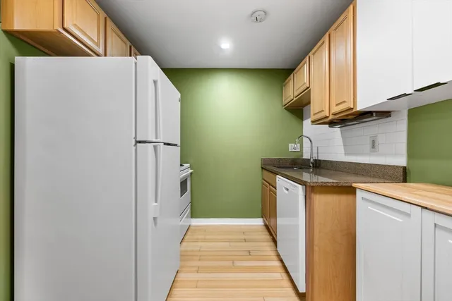 a kitchen with cabinets appliances and a wooden floor