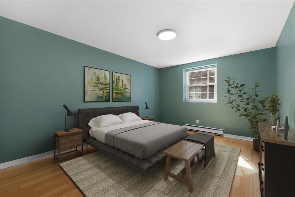 116 Sycamore Street, Unit 22 Somerville, MA 02145 - Photo 9 of 18 a bedroom with a bed wall painting and window