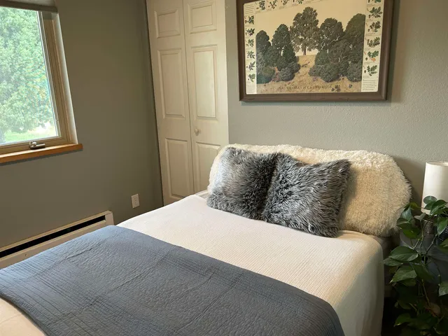 a bed sitting in a bedroom next to a window