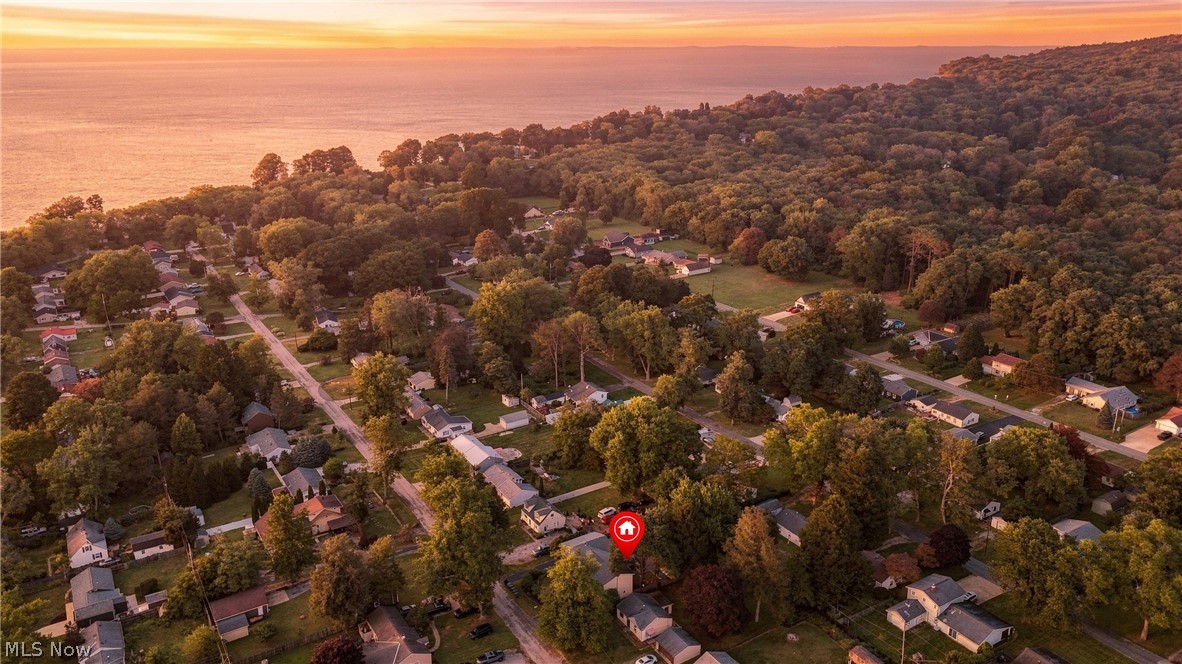 1875 Perth Road Madison, OH 44057 - Photo 46 of 48 Aerial perspective capturing a residential neighborhood with extensive tree coverage and a prominent body of water in the background