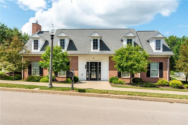 a front view of a house with a garden and plants