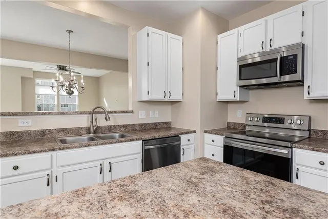 a kitchen with stainless steel appliances granite countertop a stove a sink and a microwave