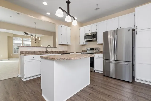 a kitchen with stainless steel appliances a refrigerator sink and microwave
