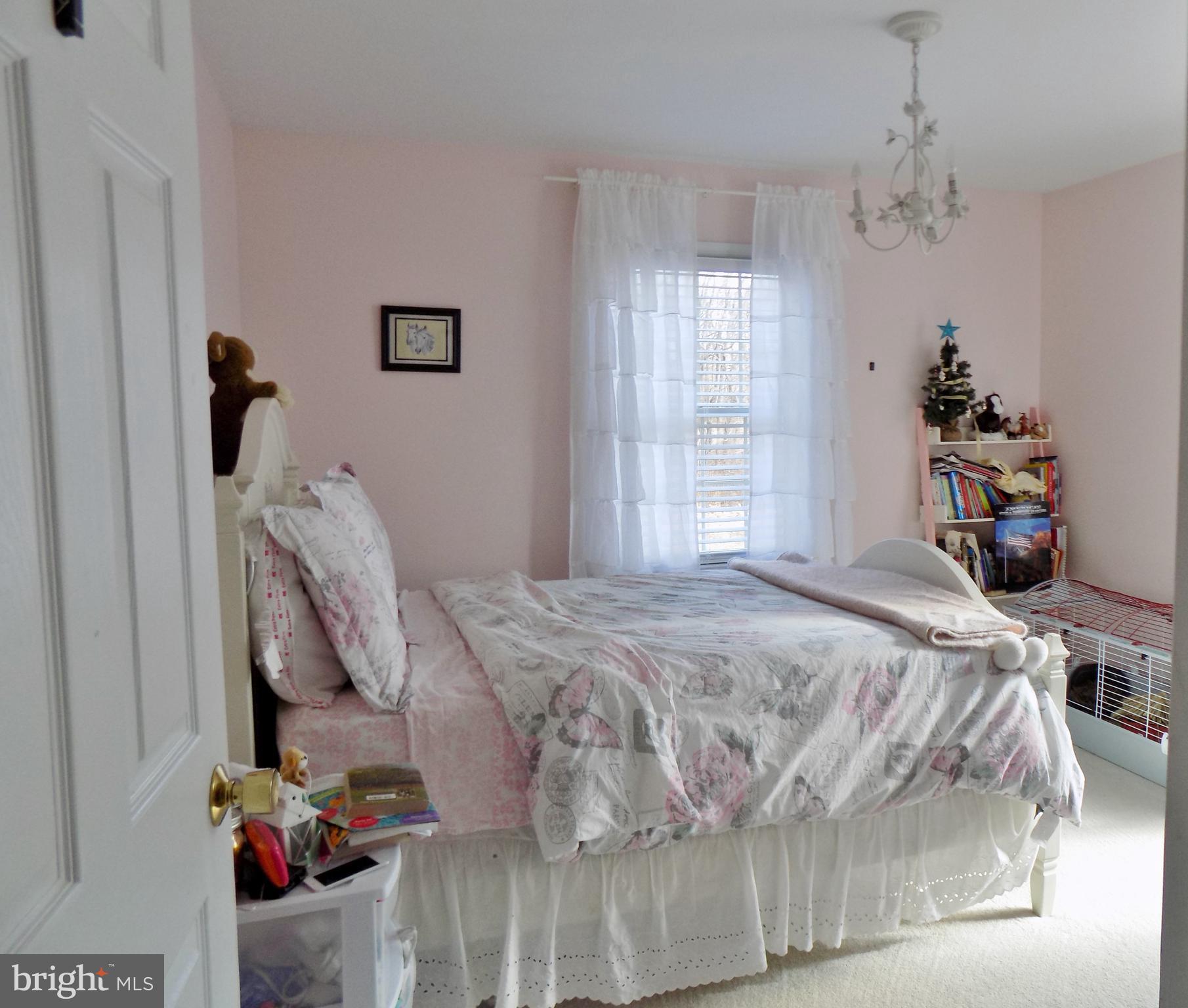 150 Longmarsh Road Berryville, VA 22611 - Photo 21 of 22 a bedroom with a bed and a chandelier