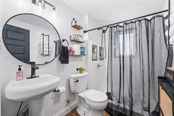 a bathroom with a toilet sink and mirror