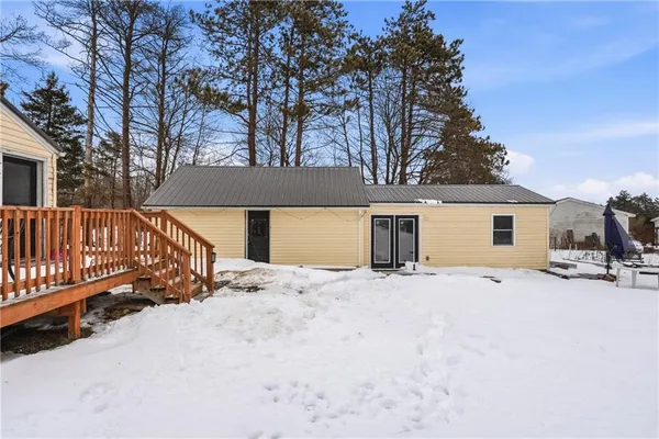 a front view of a house with a yard covered with snow