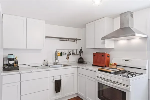 a kitchen with white cabinets and appliances