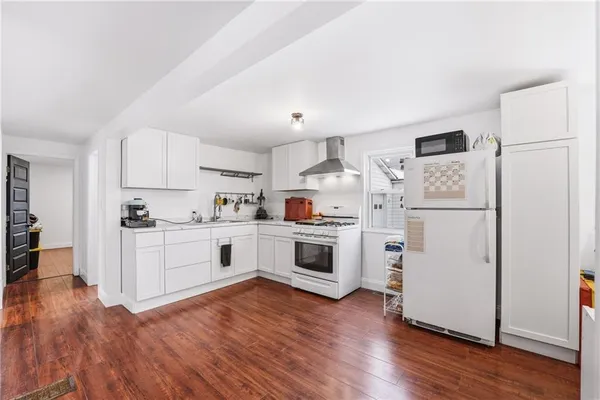 a kitchen with white cabinets and white appliances