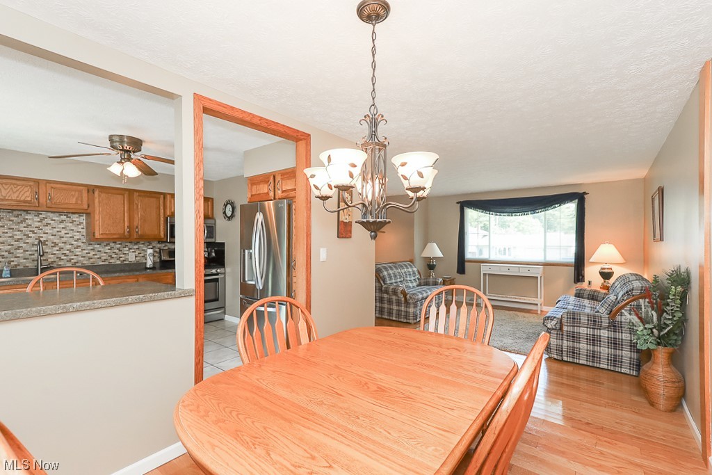 1826 Sandgate Road Madison, OH 44057 - Photo 8 of 29 Hardwood floored dining area featuring ceiling fan with notable chandelier and sink