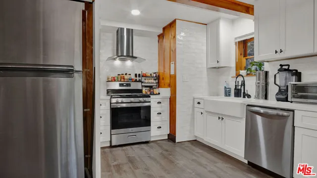 a kitchen with stainless steel appliances a refrigerator sink and cabinets