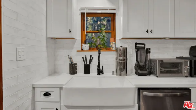 a kitchen with a white cabinets and window