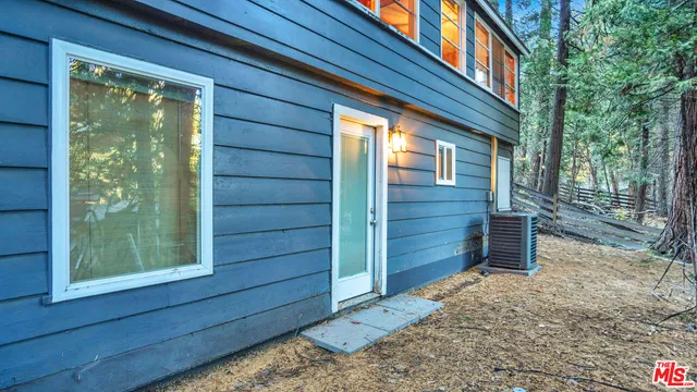 a view of a park that has large trees and a wooden fence