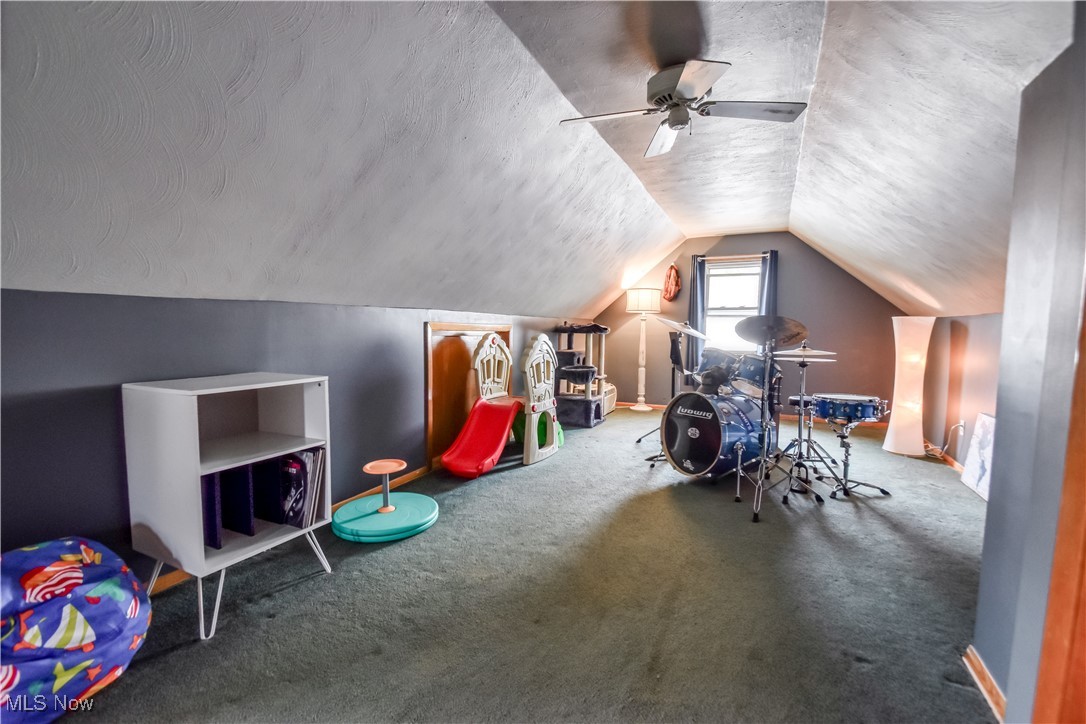 357 Clarmont Road Willowick, OH 44095 - Photo 14 of 27 Playroom with a textured ceiling, carpet flooring, lofted ceiling, and a ceiling fan