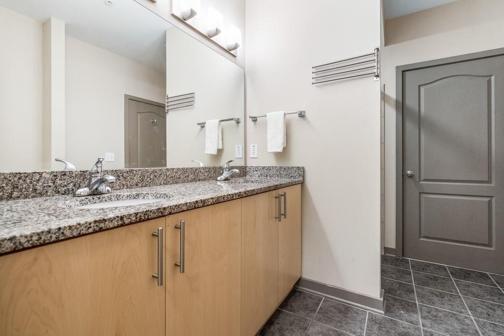 390 17th Street Northwest, Unit 3044 Atlanta, GA 30363 - Photo 22 of 31 a bathroom with a granite countertop sink and a mirror