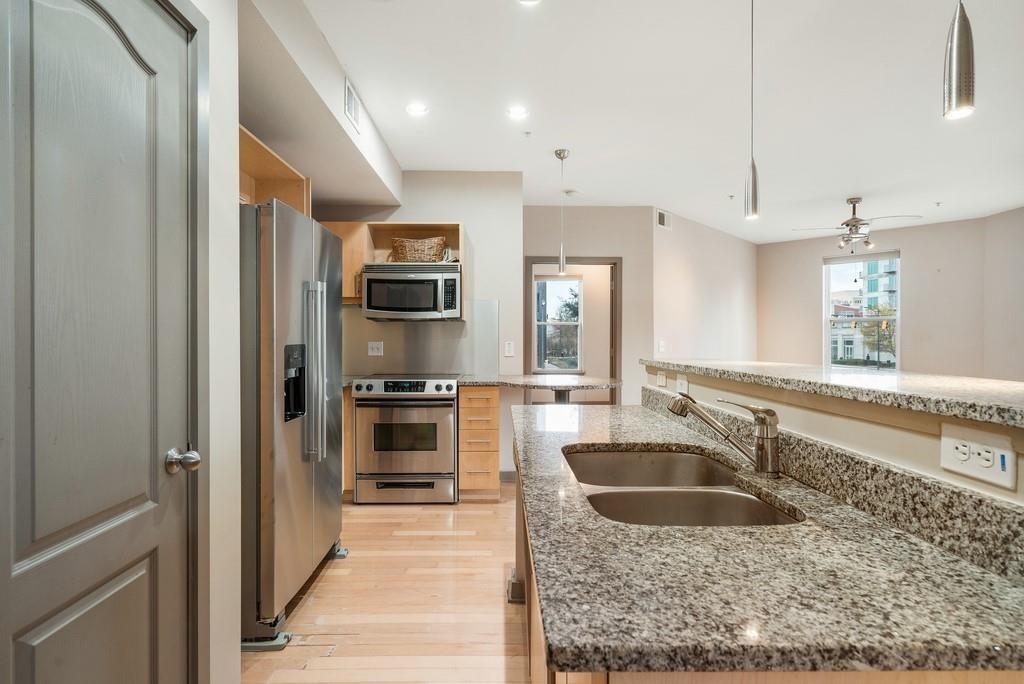 390 17th Street Northwest, Unit 3044 Atlanta, GA 30363 - Photo 4 of 31 a kitchen with stainless steel appliances granite countertop a sink a stove and a refrigerator