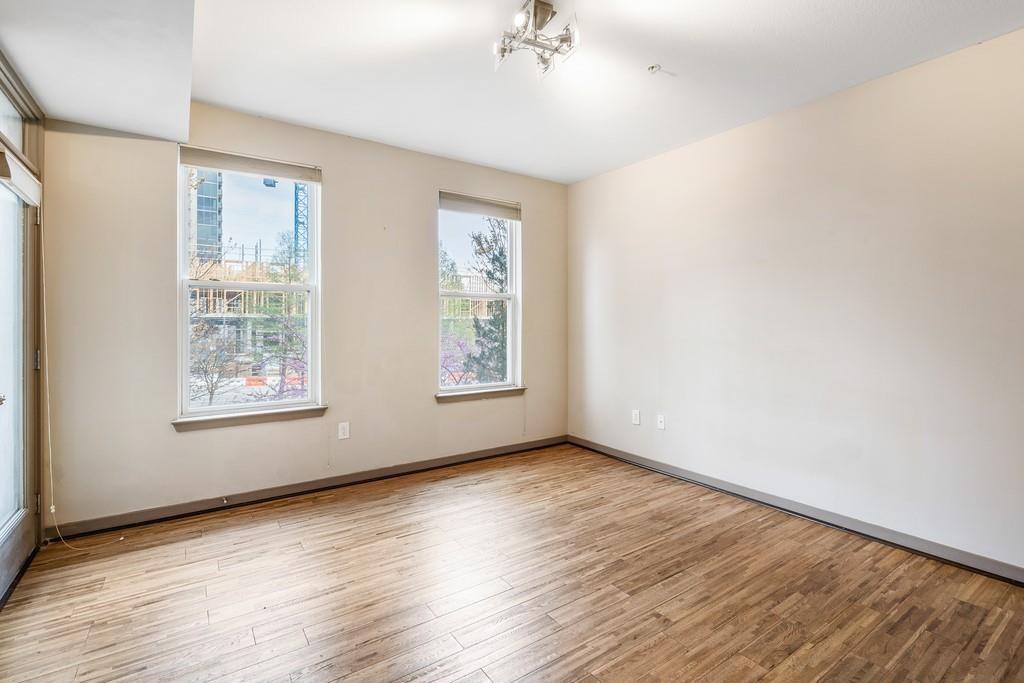 390 17th Street Northwest, Unit 3044 Atlanta, GA 30363 - Photo 9 of 31 a view of an empty room with wooden floor and a window