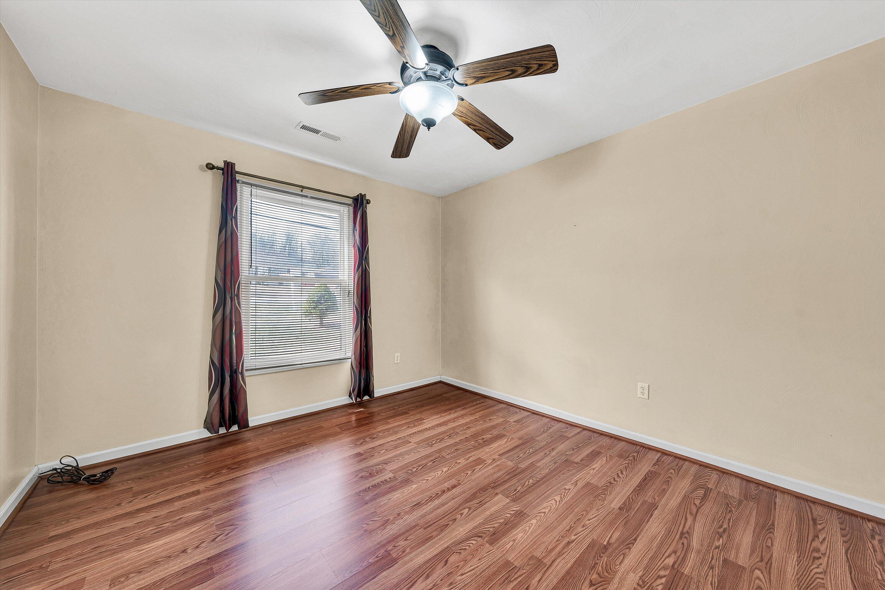 1060 Kessler Mill Road Salem, VA 24153 - Photo 11 of 31 an empty room with wooden floor chandelier fan and windows
