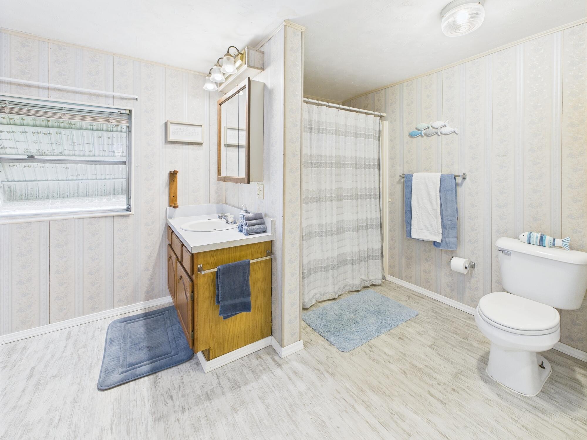3302 Southeast 34th Avenue Okeechobee, FL 34974 - Photo 23 of 54 a spacious bathroom with a granite countertop toilet a sink and a mirror