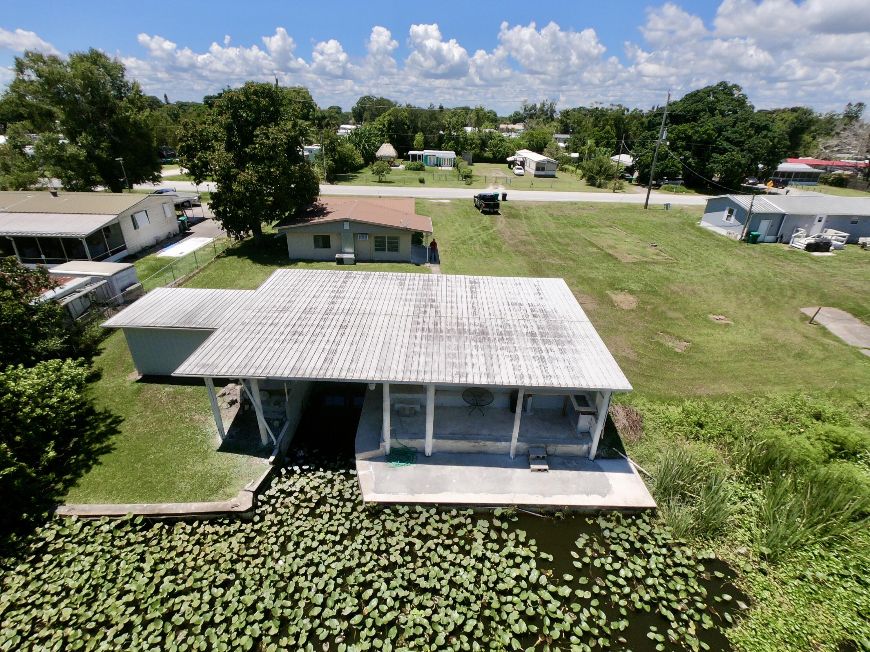 3302 Southeast 34th Avenue Okeechobee, FL 34974 - Photo 3 of 54 a front view of a house with a garden and trees