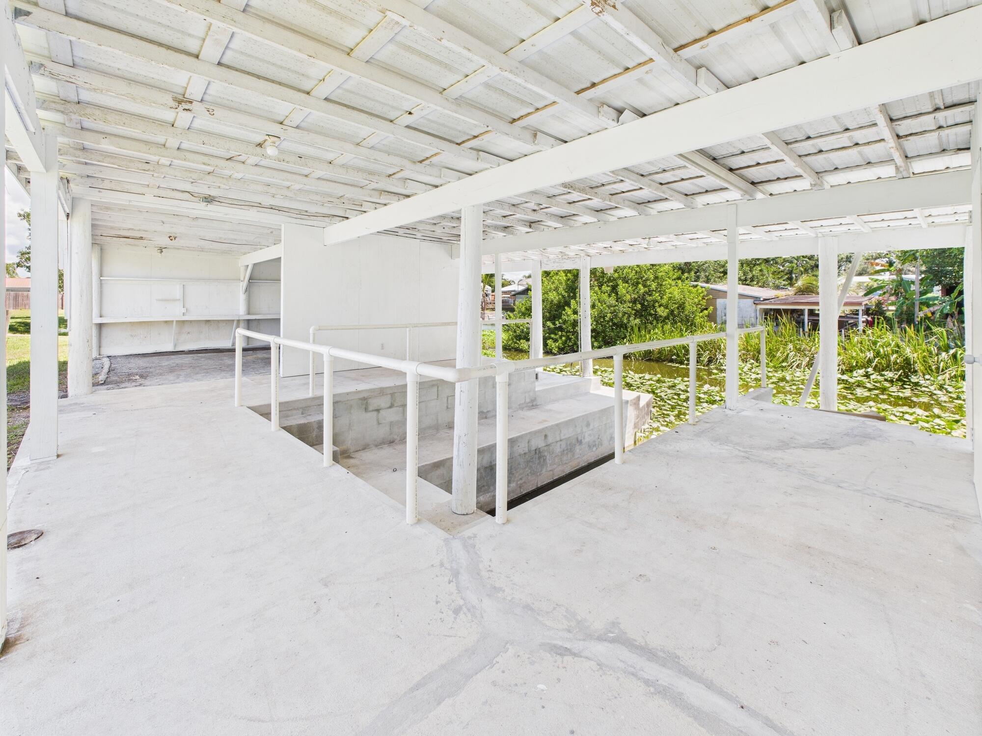 3302 Southeast 34th Avenue Okeechobee, FL 34974 - Photo 40 of 54 a view of a patio with table and chairs potted plants with wooden fence