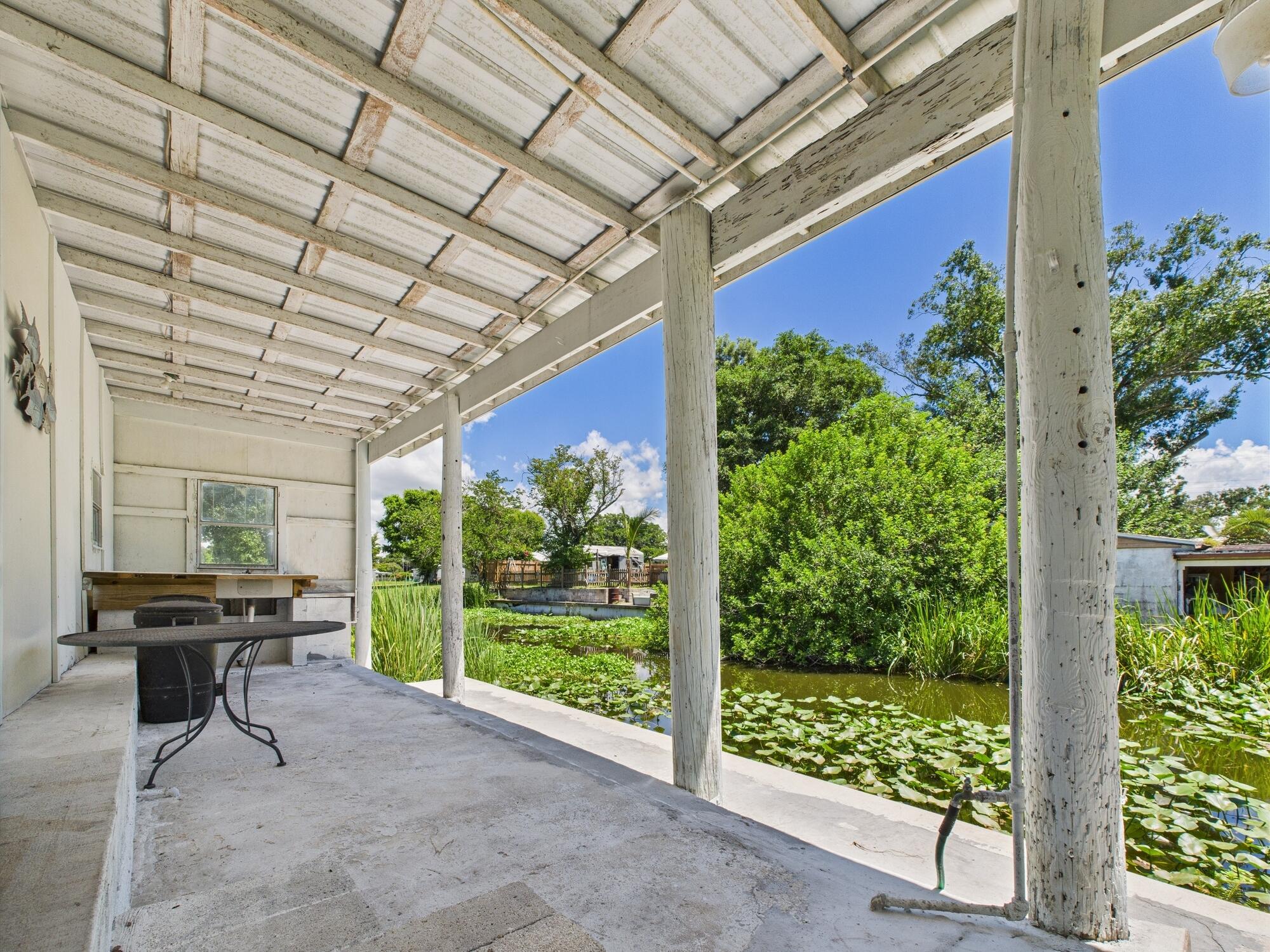 3302 Southeast 34th Avenue Okeechobee, FL 34974 - Photo 45 of 54 a view of a porch with chairs and potted plants