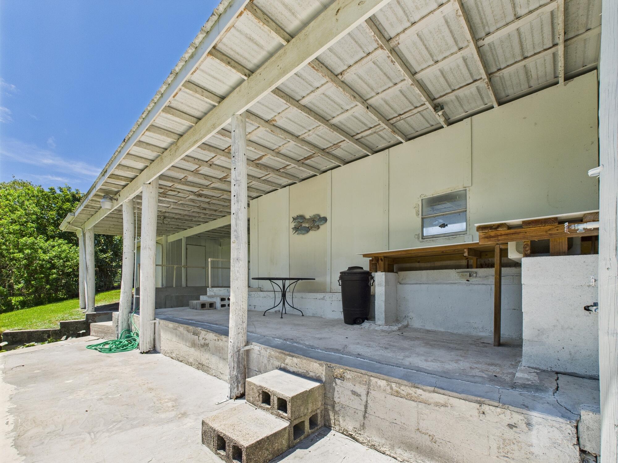 3302 Southeast 34th Avenue Okeechobee, FL 34974 - Photo 46 of 54 a view of a patio with table and chairs with wooden fence and plants