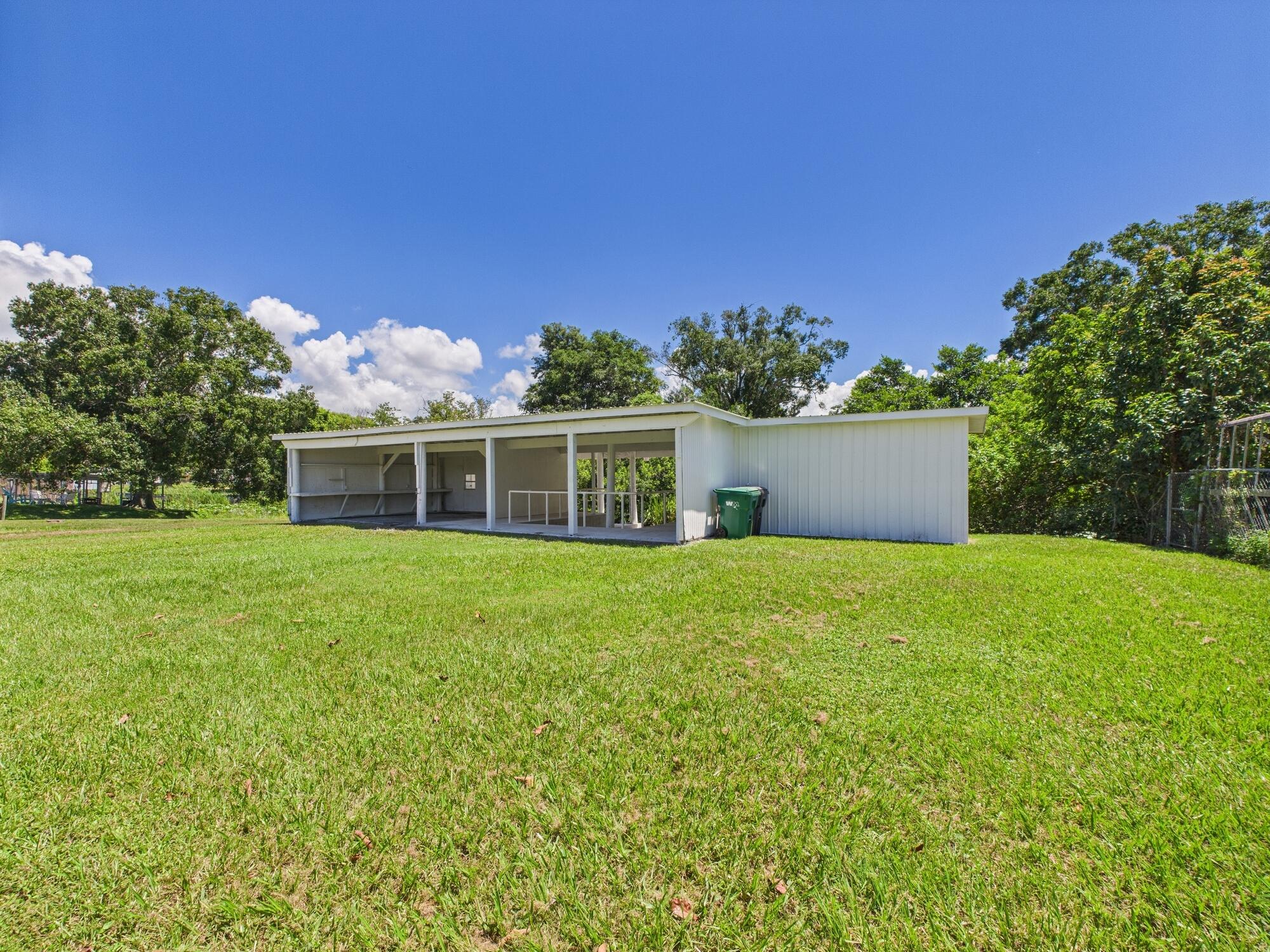 3302 Southeast 34th Avenue Okeechobee, FL 34974 - Photo 51 of 54 a front view of a house with a yard and garage