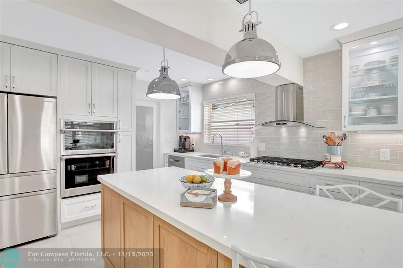 1985 Sailfish Place Pompano Beach, FL 33062 - Photo 21 of 47 a kitchen with stainless steel appliances granite countertop a sink stove and refrigerator