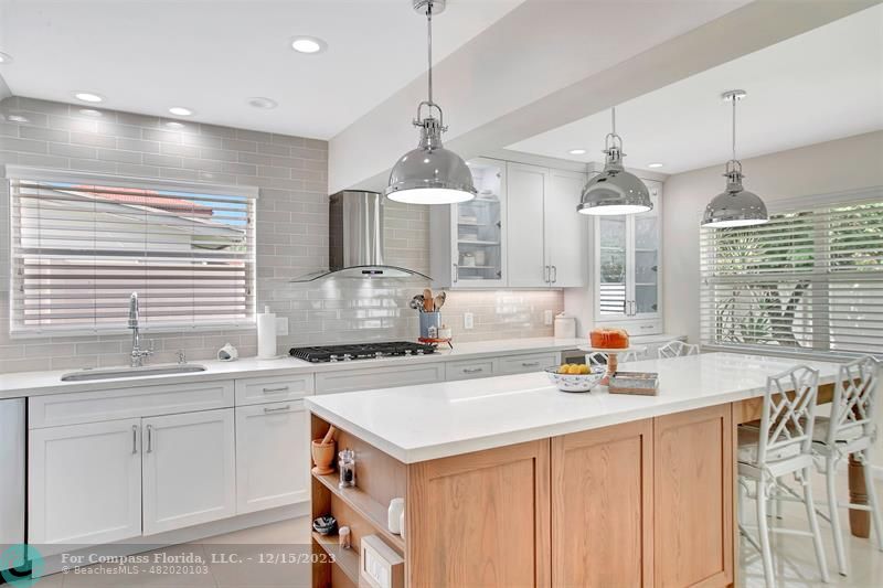 1985 Sailfish Place Pompano Beach, FL 33062 - Photo 23 of 47 a kitchen that has a sink a stove and a wooden floor