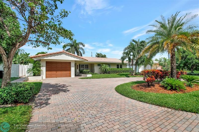 1985 Sailfish Place Pompano Beach, FL 33062 - Photo 3 of 47 a front view of a house with a garden and trees