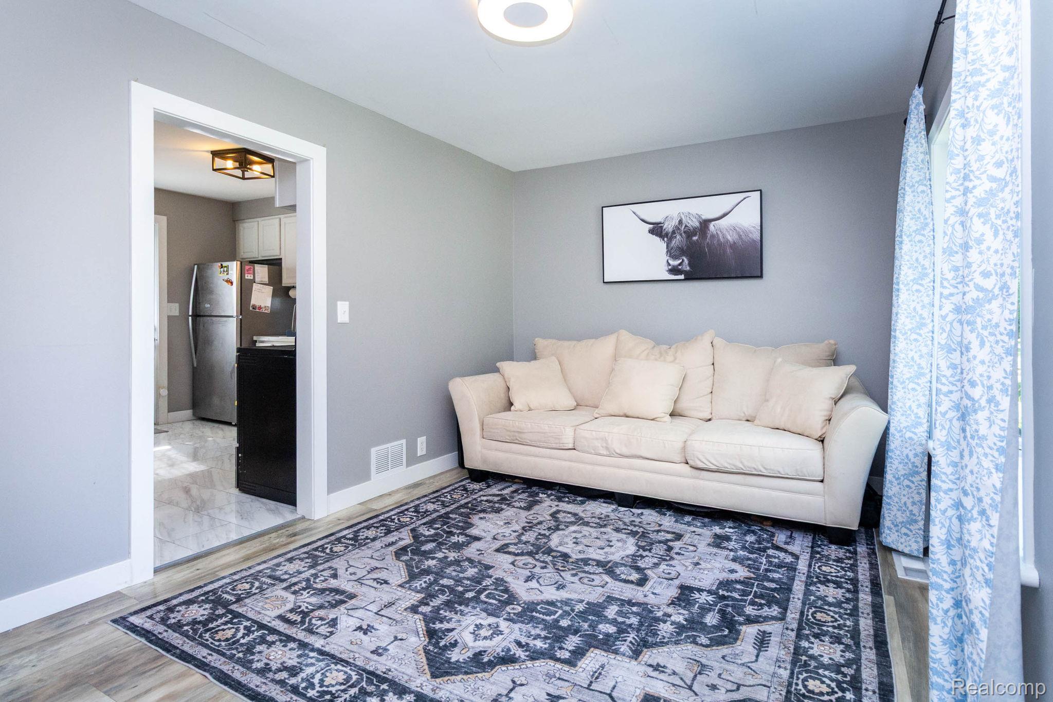 2559 Harrison Avenue Rochester, MI 48307 - Photo 6 of 32 Living area featuring light gray walls, white trim, and wood-finish flooring