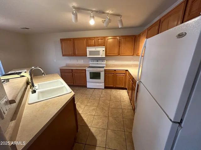 a kitchen with a refrigerator and a stove top oven