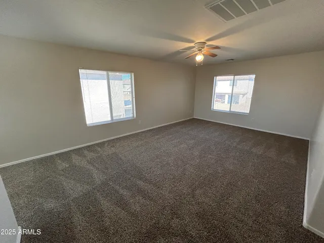 an empty room with a window and a fan