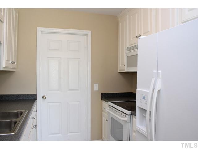 462 Axum Road Willow Spring, NC 27592 - Photo 7 of 18 a kitchen with a white cabinets and white appliances