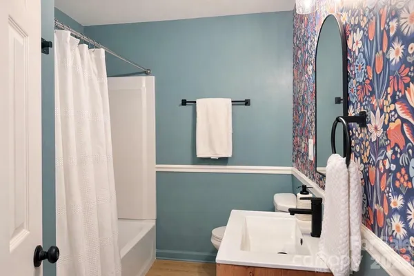 a bathroom with a sink toilet and mirror