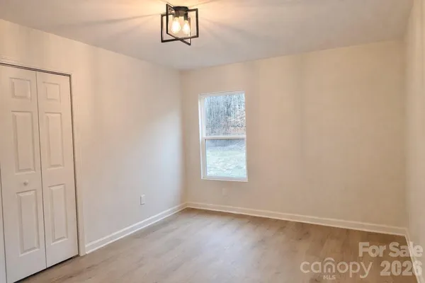 an empty room with windows and closet