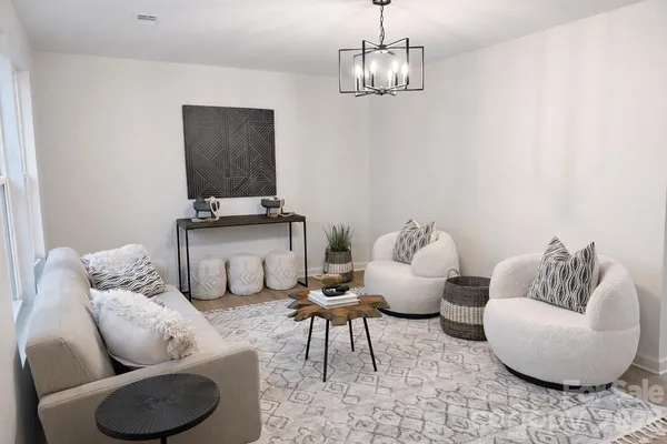 a living room with furniture and a chandelier