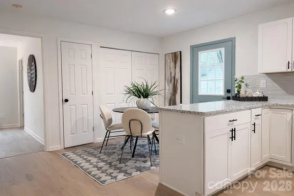 a white kitchen with kitchen island a counter top space a sink and a refrigerator