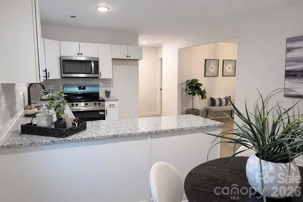 a kitchen with stainless steel appliances granite countertop a sink a stove and a refrigerator